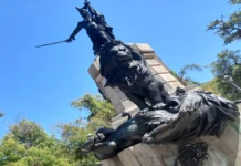 A História do Túmulo de Bento Gonçalves em Rio Grande-RS Estátua de um homem erguendo uma espada e abaixo dele dois leões brigando.