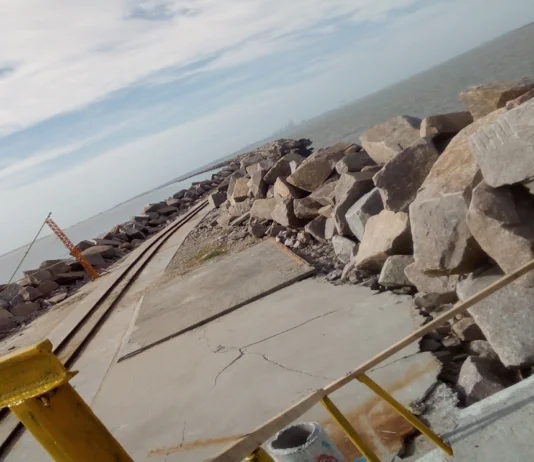 Os Molhes da Barra de Rio Grande no Cassino Extremidade final dos molhes da barra, com trilho de ferro para vagonetas sobre uma pista longa e estreita, cercadas por enormes pedras que fazem barreira com o oceano.