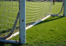 A História Completa do Sport Club Rio Grande Uma trave de futebol aparecendo somente a metade de baixo, sobre o gramado verde. A trave é branca com alguns pontos de ferrugem.